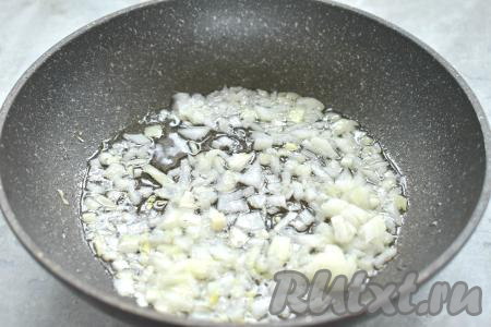 Очищаем морковку и лук. В сковороде прогреваем растительное масло, после этого выкладываем мелко нарезанную луковицу и обжариваем на среднем огне до прозрачности (минуты 3), иногда перемешивая.