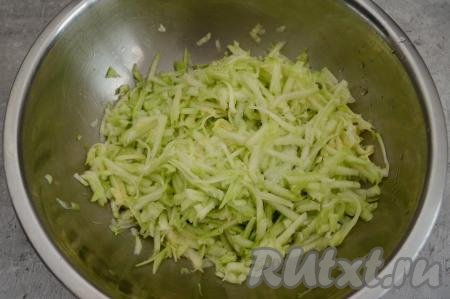 Очистить кабачок от кожуры. Кабачок лучше выбирать молодой, без крупных семечек. Если же у кабачка крупные семечки, тогда их нужно будет убрать. 450 грамм очищенного кабачка натереть на крупной тёрке, посолить, перемешать.