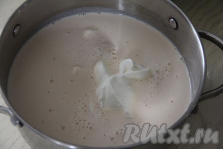 В кастрюлю влить ряженку, добавить сметану, тщательно перемешать массу венчиком.&nbsp;