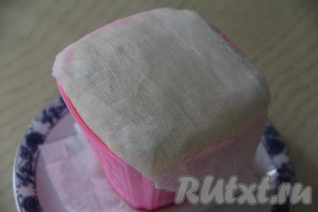 Накрыть верх пасхи марлей. Поставить сверху гнёт (я поверх марли ставлю блюдце, на которое помещаю банку с водой). Поместить пасху под гнётом в холодильник на сутки. Периодически менять сырое бумажное полотенце, которое будет впитывать жидкость, выделяющуюся из творожной массы.