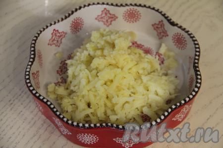 Салат "Мимоза" можно выкладывать слоями в керамическую форму или кулинарное кольцо диаметром 18 сантиметров. Почистить картошку, натереть на крупной тёрке, выложить в форму первым слоем, разровнять, слегка посолить.