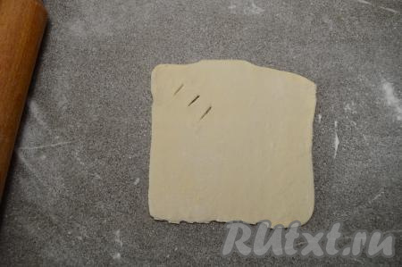 Каждый квадратик раскатать до толщины примерно 2 миллиметра. У меня получился квадратик размером 15 на 15 сантиметров. Сделать ближе к одному из углов теста 3 разреза шириной по 1 сантиметру, как на фото.