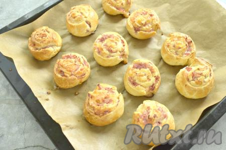 Ставим противень с рулетиками с колбасой и сыром в разогретую духовку. Выпекаем 15-20 минут (до подрумянивания слоёного теста) при температуре 180 градусов.