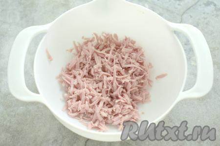 Когда тесто разморозится, включаем духовку разогреваться до 180 градусов и приступаем к формированию слоек. Колбасу натираем на крупной тёрке в глубокую миску.