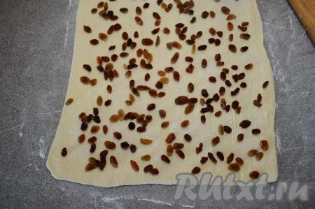 Затем равномерно присыпать тесто 30 граммами сахара, разложить половину обсушенного изюма.