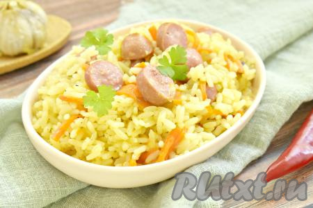 Вот так просто и быстро можно приготовить ароматный, сытный и вкусный плов с сосисками, раскладываем его по тарелкам и подаём к столу.