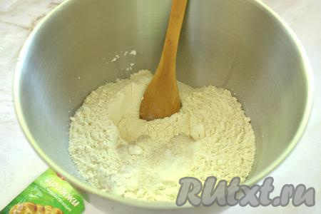 Прежде всего замесим дрожжевое тесто, для этого в достаточно объёмную миску просеиваем муку, всыпаем сухие дрожжи, сахар и соль, хорошо перемешиваем, образуя в центре получившейся смеси углубление.