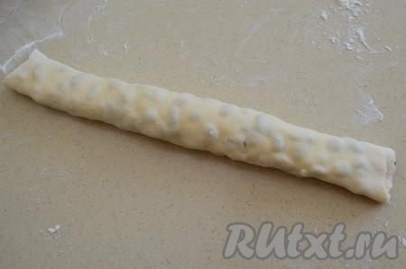 Свернуть тесто в рулет, начиная с длинного края. Руками немного прижать рулет по всей длине, чтобы он получился более плотным.