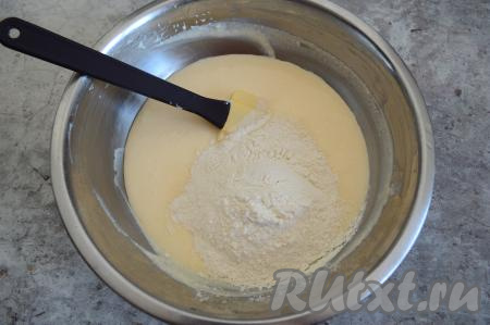 Начать понемногу добавлять смесь муки и разрыхлителя в творожную массу.