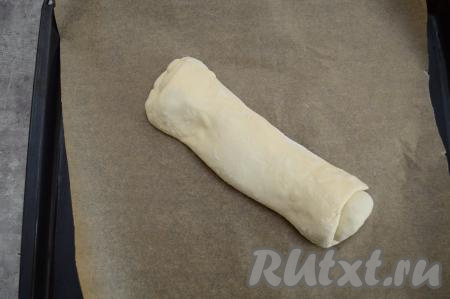 Аккуратно переложить рулет на противень, застеленный пергаментом. Если не уверены в качестве пергамента, которым вы застелили противень, тогда перед выкладыванием рулета слегка смажьте бумагу растительным маслом.