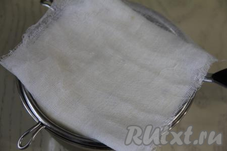 Накрыть творожную массу сверху краями марли. Сито с творожной пасхой поставить на глубокую миску (или кастрюльку), чтобы туда стекала жидкость, которая будет выделяться из творожной массы. Поверх марли поставить тарелку, сверху разместить небольшой гнёт (например, банку с водой). Поставить всю конструкцию в холодильник на сутки.