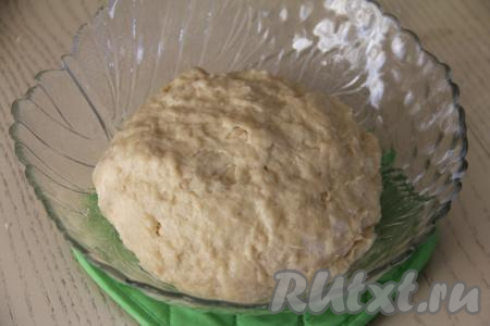 Руками вмешать масло в тесто. Затем также руками вымесить тесто до гладкого состояния. Вымешивать примерно 10 минут. Сначала тесто будет расслаиваться, а затем соберётся в гладкий ком. Итоговое тесто для куличей должно практически не липнуть к рукам. Оставить его в миске, накрыв пищевой плёнкой (или полотенцем), на 1,5 часа в тёплом месте.