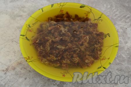 Пока тесто подходит, можно заняться начинкой для куличей. Изюм поместить в глубокую тарелку, полностью залить кипящей водой и оставить на 5-10 минут.