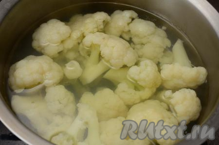 В кастрюлю выложить соцветия капусты. Залить цветную капусту полностью водой и поставить на сильный огонь. После закипания воды посолить по вкусу, уменьшить огонь и варить минут 6-8 (соцветия должны хорошо держать форму, но при этом легко прокалываться ножом).