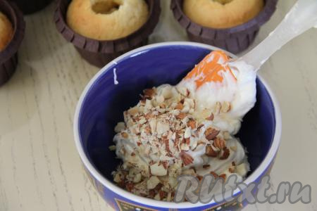 От общей массы крема отложить 60 грамм. В эти 60 грамм крема добавить миндаль, нарезанный ножом на мелкие кусочки, перемешать лопаткой и начинка для кексов готова. Оставшийся крем, в который мы не добавляли миндаль, выложить в кулинарный мешок с фигурной насадкой.