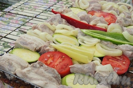 Дополнительно мы запекли на решетеке овощи. Баклажан нарезать, присыпать солью и оставить его на 10-15 минут (так мы избавимся от горечи). Остальные овощи произвольно нарезать и посолить. На решётку (при желании можно приготовить шашлык и на шампурах) плотно выкладывать маринованную свинину, маринованный лук, нарезанные свежие овощи (у меня помидор, баклажан, цукини, сладкий перец).
