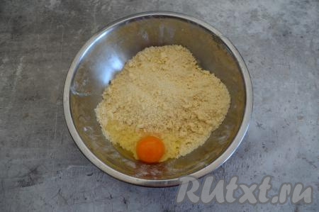 Руками перетереть масло с мучной смесью до получения мелкой крошки. Затем вбить в миску сырое яйцо. Я добавила деревенское яйцо, оно придало яркий цвет песочному тесту.