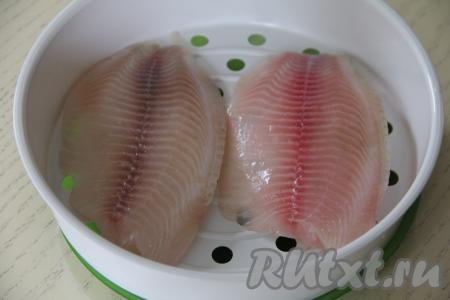 Затем выложить тилапию на поддон для готовки на пару.