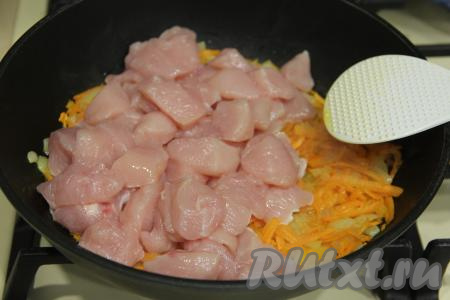 К обжаренным овощам добавить куриное филе, нарезанное на средние кубики, перемешать.