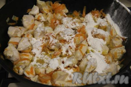 Обжаривать мясо курицы с овощами минут 10, иногда перемешивая. Затем всыпать муку, перемешать.
