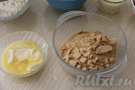 Сливочное масло растопить. Печенье измельчить в мелкую крошку. Для измельчения печенья можно воспользоваться измельчителем. А можно поместить печенье в целлофановый пакет и прокатать поверх пакета скалкой, измельчая печенье.