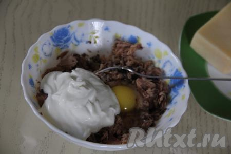 В глубокую тарелку выложить консервированного тунца без жидкости. Размять рыбу вилкой, добавить яйца и сметану.