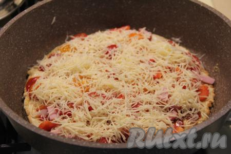 Сверху присыпать пиццу натёртым сыром.