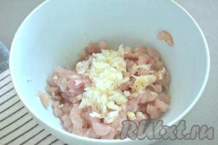 Очищаем лук и чеснок. Лук нарезаем на мелкие кусочки. Чеснок пропускаем через пресс (или натираем на мелкой тёрке) и вместе с луком добавляем к куриному филе.