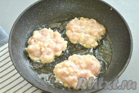 Разогреваем на сковороде растительное масло, затем по 1 столовой ложке выкладываем куриную массу в виде круглых оладий.