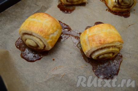 Поставить противень в духовку, заранее разогретую до 200 градусов, выпекать булочки с корицей и сахаром минут 20-25 (до румяности слоёного теста). Во время выпечки из слоек будет вытекать часть сахара - это нормально, так как сахар плавится при выпечке. Несмотря на потерю части сахара, слоёные булочки всё равно получатся в меру сладкими.