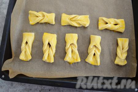 С помощью кулинарной силиконовой кисочки смазать каждую заготовку хвороста взбитым яйцом.