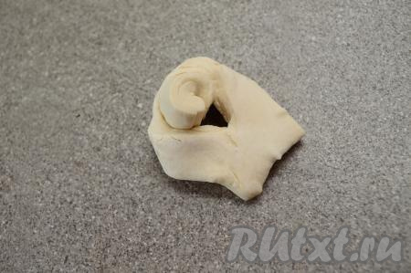 Взять один узкий край теста и продеть через надрез.&nbsp;