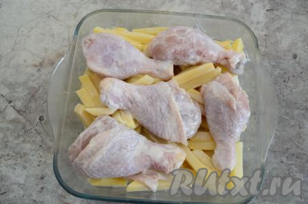Ровным слоем выложить картошку в форму для запекания. Поверх картофеля разложить голени. Форму для запекания я маслом перед выкладыванием картошки не смазывала, так как курица, сметана и картофель во время запекания выделяют жидкость, поэтому блюдо к форме не пристаёт.