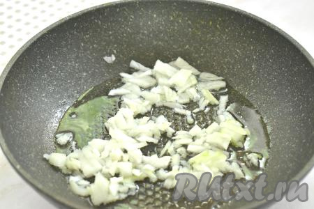 Прогреваем растительное масло в сковороде, выкладываем мелко нарезанный лук и обжариваем его до прозрачности (минуты 3) на среднем огне, иногда помешивая.