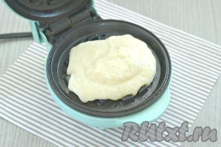 Панели электровафельницы смазываем растительным маслом и разогреваем. На нижнюю панель кладём 2 столовых ложки дрожжевого теста.