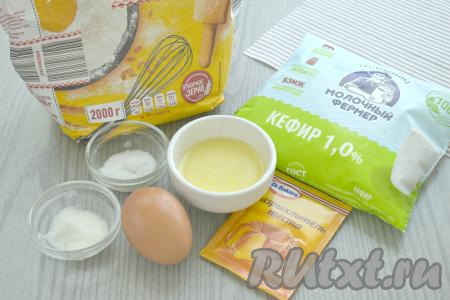 Подготовим продукты для замешивания бездрожжевого теста на кефире для жареных пирожков. Кефир можно взять любой жирности, в этот раз я использовала кефир жирностью 1%. Кефир должен быть тёплым. Я подогрела кефир в микроволновке в течение 20 секунд. Сливочное масло нужно растопить и остудить.