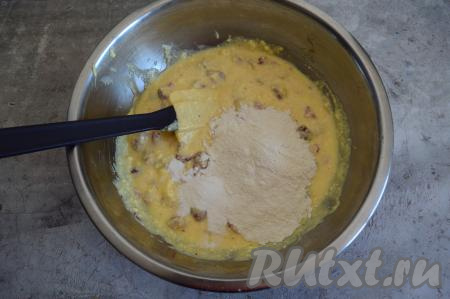 Вмешать ягоды в тесто лопаткой. Всыпать разрыхлитель и примерно половину муки.