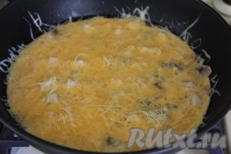 Сверху равномерно присыпать омлет сыром, натёртым на мелкой тёрке.