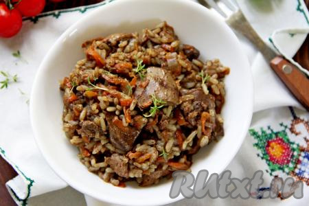 Рассыпчатый рис вместе с мягкой, нежной куриной печенью разложить со сковороды по тарелкам и в горячем виде подать сытное, аппетитное и вкусное блюдо к столу.