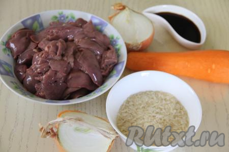 Подготовить продукты для приготовления на сковороде куриной печени с рисом. Лук и морковь почистить. Куриную печень промыть водой и немного обсушить. Рис всыпать в сито и тщательно промыть под проточной водой, после этого оставить на несколько минут, чтобы стекла лишняя жидкость.