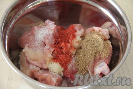 Порционные части курицы (у меня - куриные бёдра) промыть, обсушить, выложить в миску, добавить специи, соль и пропущенный через пресс чеснок, перемешать. Я использовала в качестве специй по 1 чайной ложке хмели-сунели и молотой паприки.