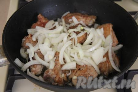 К курице, обжаренной до румяности, добавить очищенный лук, нарезанный на полукольца, перемешать, обжаривать на среднем огне, периодически перемешивая, минут 5.