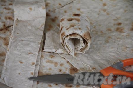 Лист лаваша свернуть в рулет и нарезать на рулетики шириной примерно 7-8 сантиметров.