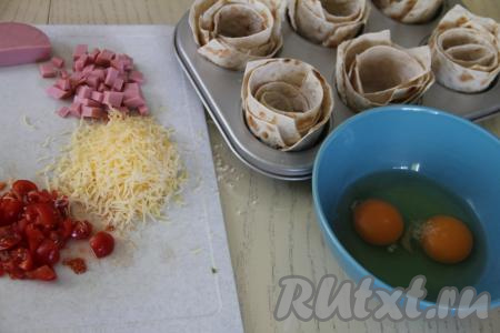 Помидоры вымыть. Колбасу и помидоры нарезать на мелкие кубики. Сыр натереть на мелкой тёрке.