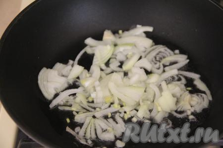 Лук нарезать на полукольца. В сковороде прогреть растительное масло, выложить полукольца лука. Обжарить лук на среднем огне до прозрачности (на это потребуется минуты 3-4), иногда помешивая.