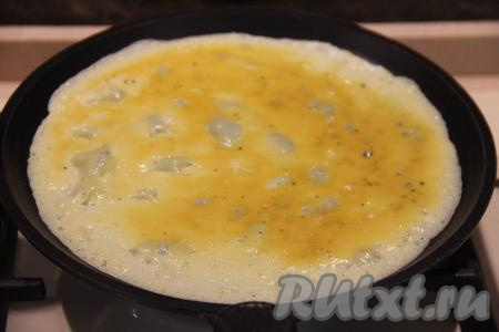 Сковороду разогреть и смазать растительным маслом. Влить 1/2 половника яичной массы в сковороду и равномерно распределить. Жарить яичный блин на среднем огне, пока низ блинчика не схватится. Я жарила блинчики на сковороде диаметром 20 сантиметров.