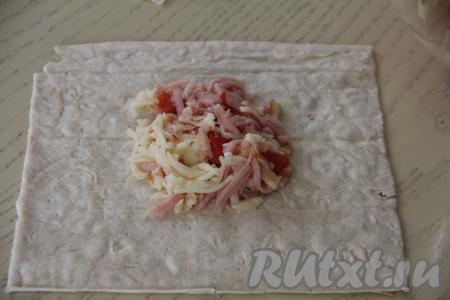 Каждый лист лаваша нарезать на прямоугольники (я каждый лист лаваша разрезала на 4 прямоугольника, соответственно из 2 лавашей у меня получилось 8 прямоугольников для формирования конвертиков). Начинку я зрительно разделила на 8 равных частей. Выложить часть начинки на середину одного прямоугольника из лаваша.