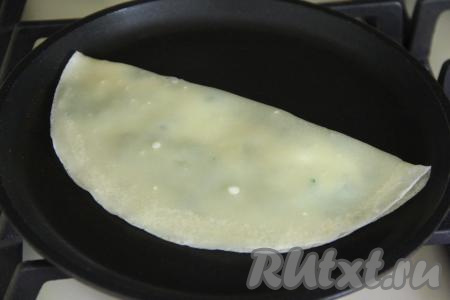 Накрыть свободной частью блина начинку и прижать края лопаткой, формируя кутаб в виде полумесяца. Края сразу прилипнут.