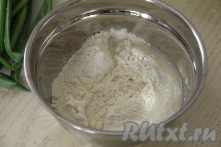 В миску с мукой и солью постепенно вливать воду, тщательно перемешивая тесто венчиком.