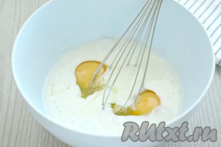 Теперь займёмся замешиванием теста для заливного пирога. Кефир должен быть комнатной температуры, поэтому вы можете достать его из холодильника заранее, либо подогреть в течение секунд 20 в микроволновке. В объёмную миску вливаем кефир комнатной температуры, добавляем сырые яйца и перемешиваем венчиком до однородности.